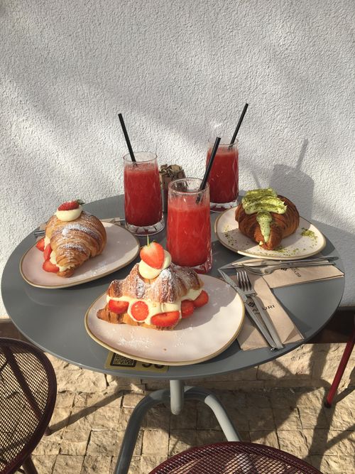 Free Tasty croissants with fruit and smoothies on an outdoor cafe table. Stock Photo