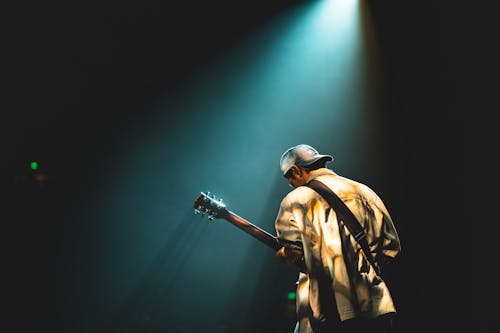 Фотография человека, играющего на гитаре