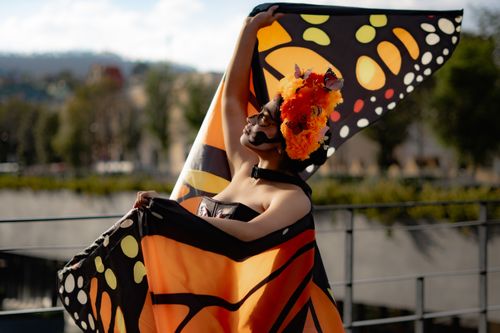 Free Woman in butterfly-themed costume and makeup poses outdoors, celebrating art and creativity. Stock Photo