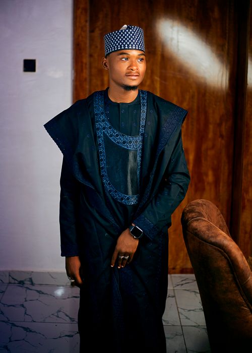 Free Confident young man wearing Nigerian agbada, standing indoors. Stock Photo