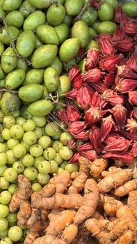 An assortment of fresh amla, roselle, and raw turmeric showcased in a Dhaka market.
