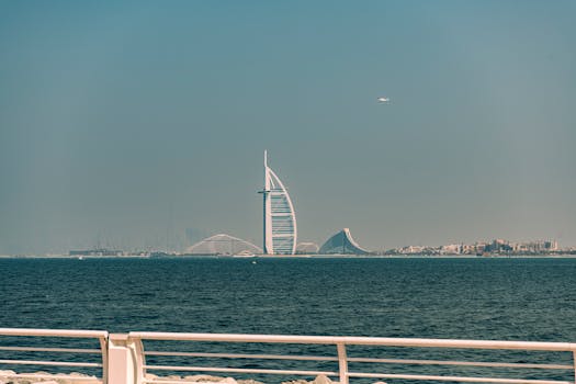 A majestic view of Burj Al Arab with the ocean in the foreground from Dubai's coastline.