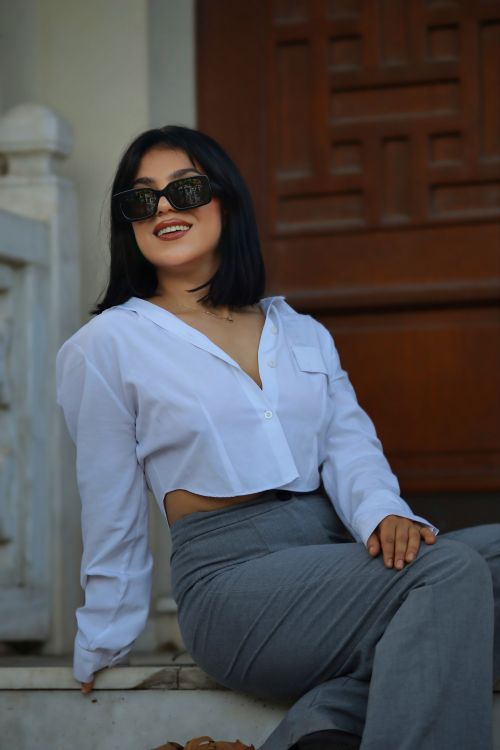 Free Confident woman in sunglasses and professional attire sitting outdoors, exuding style and sophistication. Stock Photo