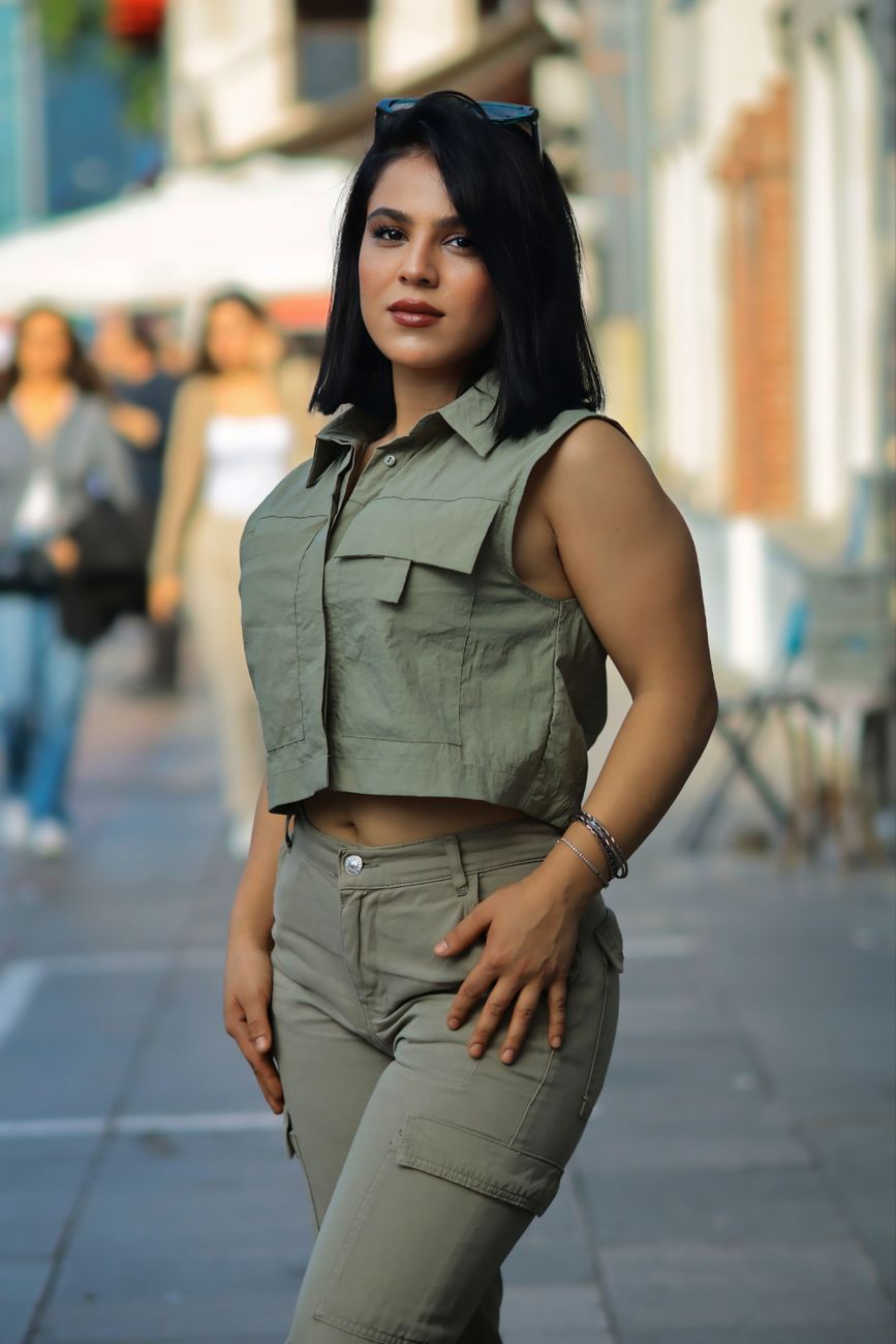 Confident woman in stylish outfit poses on an urban street, exuding fashion and modernity.