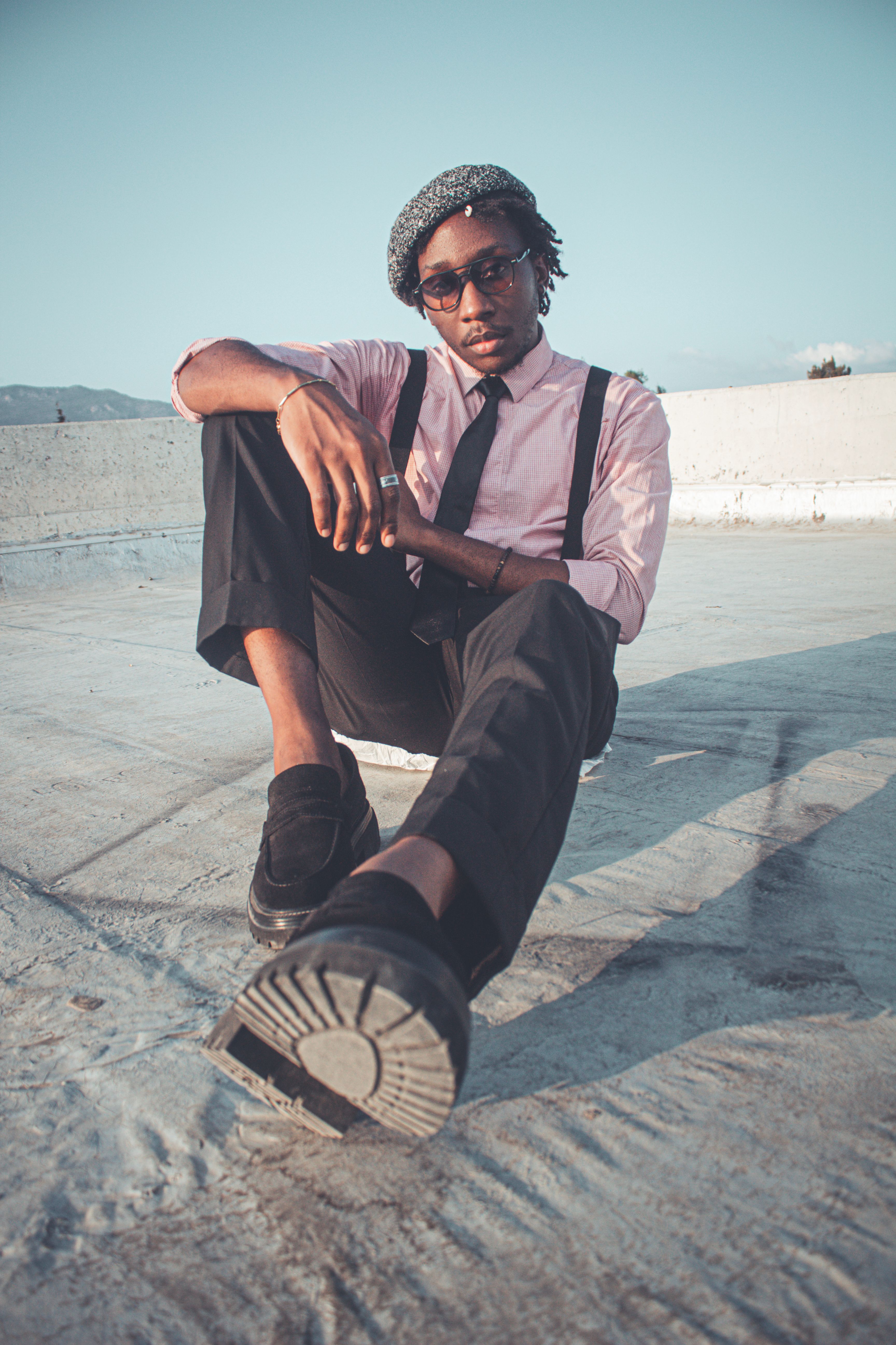 Stylish man posing on a rooftop in cityscape setting · Free Stock Photo