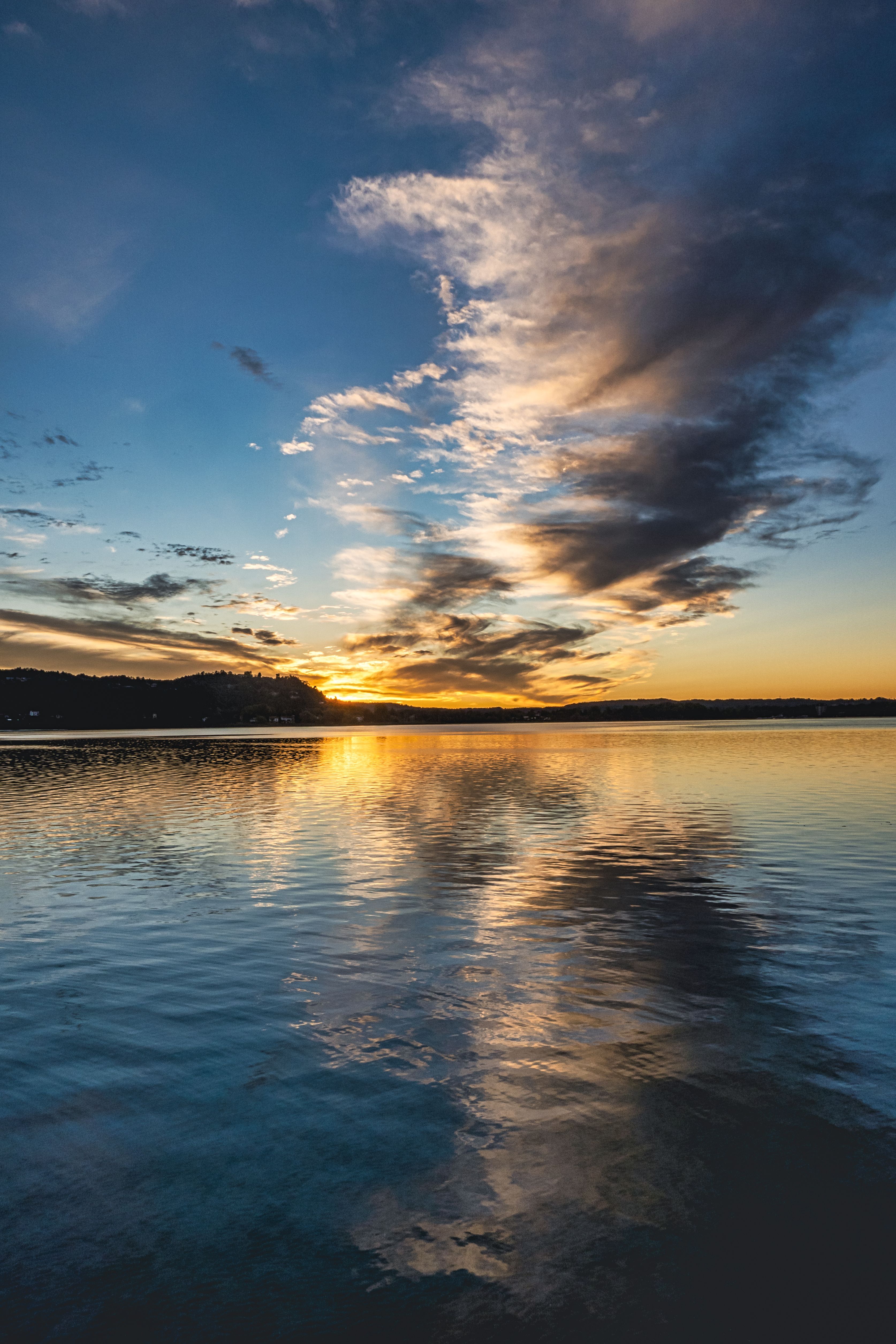 Dramatic Sunset Over Calm Lake Waters · Free Stock Photo