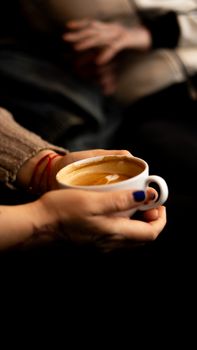 Close-up of hands holding a steaming cup of coffee, exuding warmth and comfort.. close, hands, holding