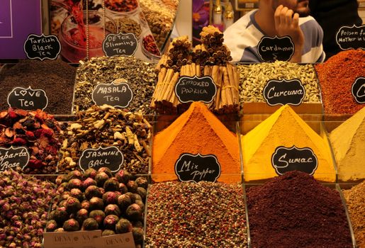 Colorful assortment of traditional Turkish spices and teas in a bustling market setting.