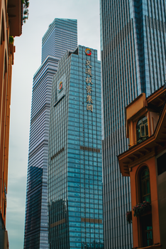 Tall skyscrapers with reflective glass in a bustling urban environment.