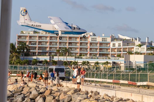 A plane flies low over tourists at Maho Beach, Sint Maarten, near the airport.