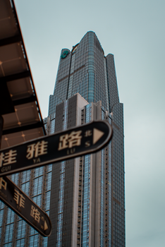 Tall skyscraper with street signs in Chinese, cityscape view