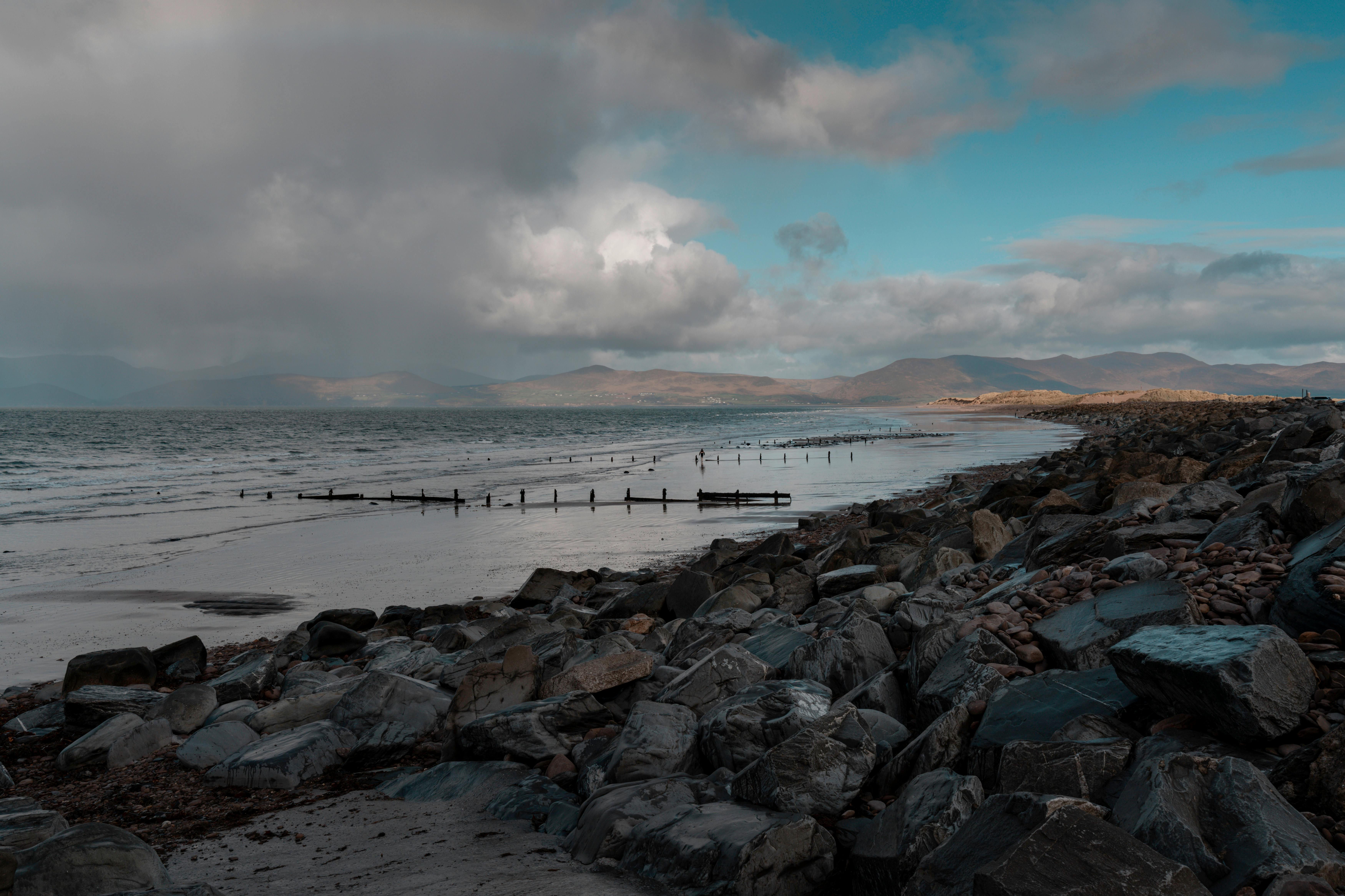 Dramatic coastal landscape in Ireland with rocky beach and distant mountains.