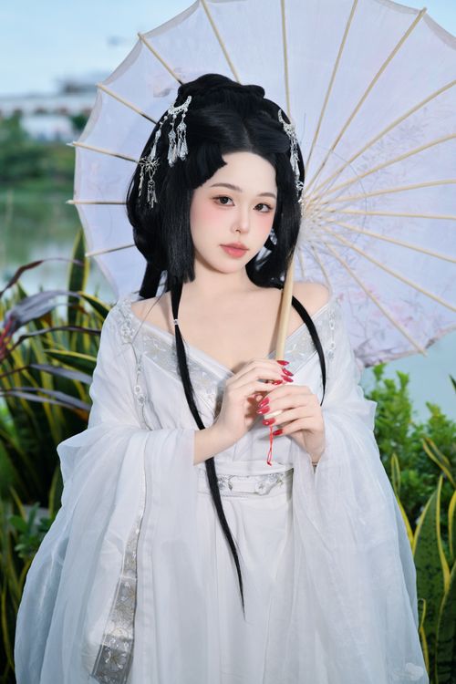Free A woman in a traditional Chinese dress with a parasol, exuding cultural elegance. Stock Photo