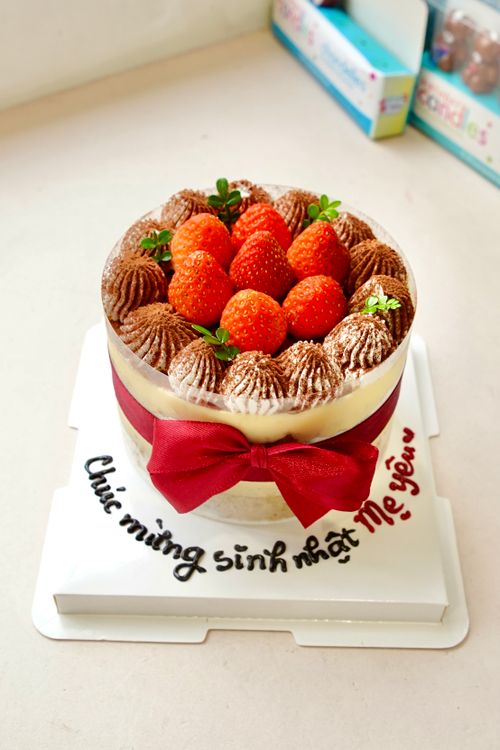 Free Delicious birthday cake topped with strawberries and chocolate greeting. Stock Photo