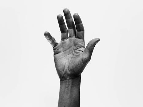 A high-contrast black and white image showcasing the intricate details of an outstretched hand.