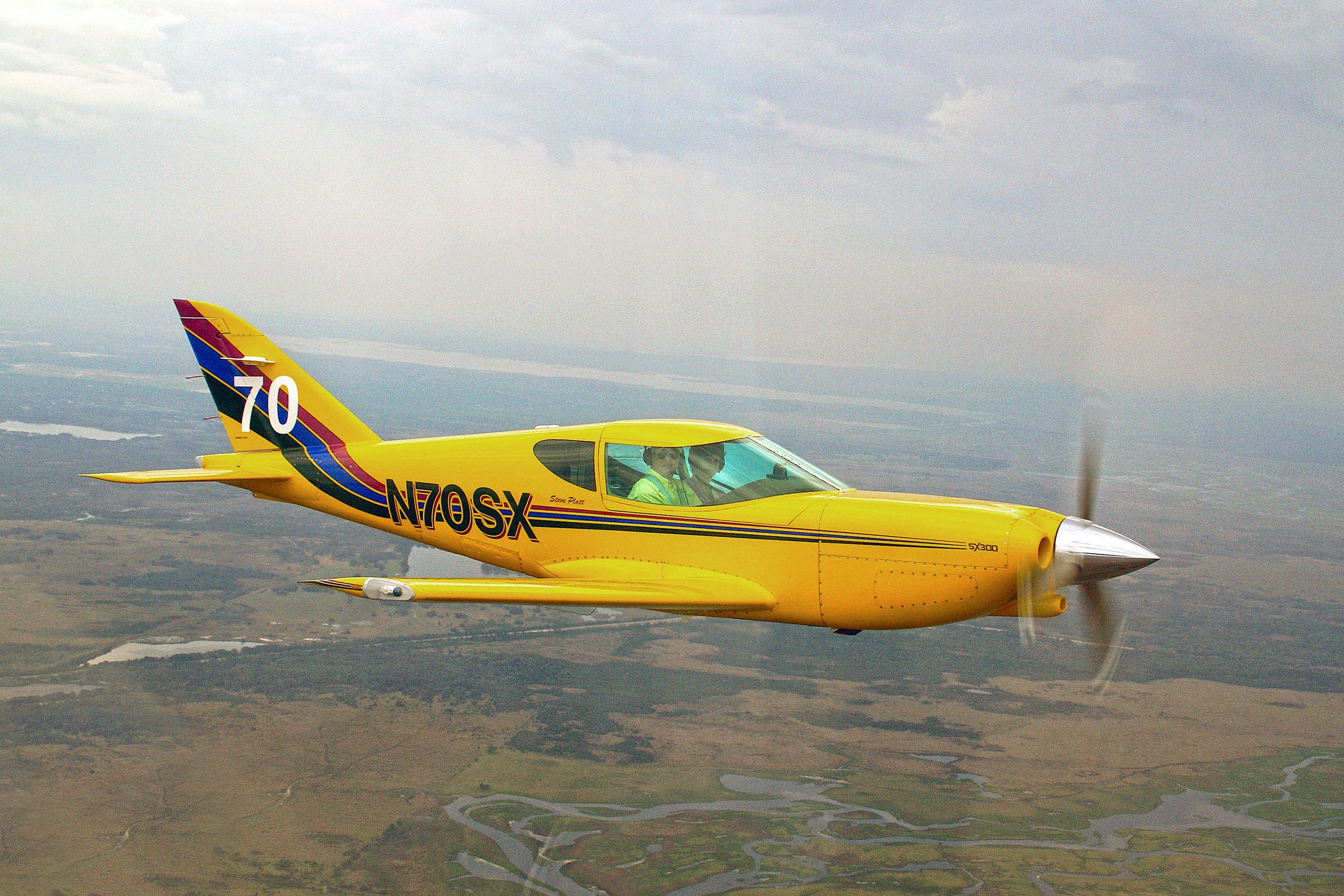 Bright yellow aircraft in flight over the scenic Florida landscape. Aerial view captures vibrant design.