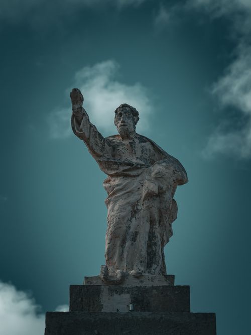 Free A majestic stone statue depicting a historical figure reaching out to the sky, exuding strength and power. Stock Photo