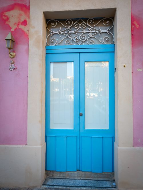 Free Vibrant blue door with intricate metalwork in a colorful Mediterranean street. Stock Photo