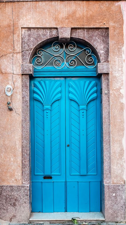 Free Discover the beauty of Mediterranean architecture with this vivid blue ornate door captured in daylight. Stock Photo