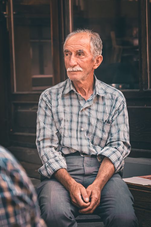 Free A senior man in a plaid shirt sits pensively outdoors in Bolu, Türkiye. Stock Photo