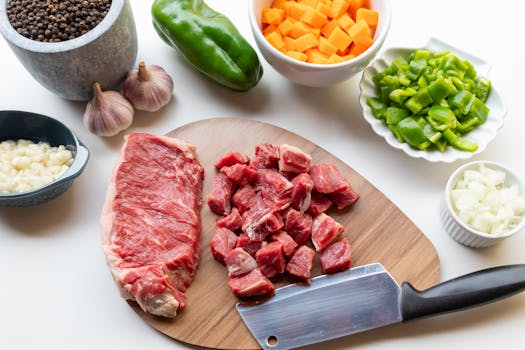 A variety of fresh ingredients including beef, vegetables, and seasonings ready for a homemade stew.