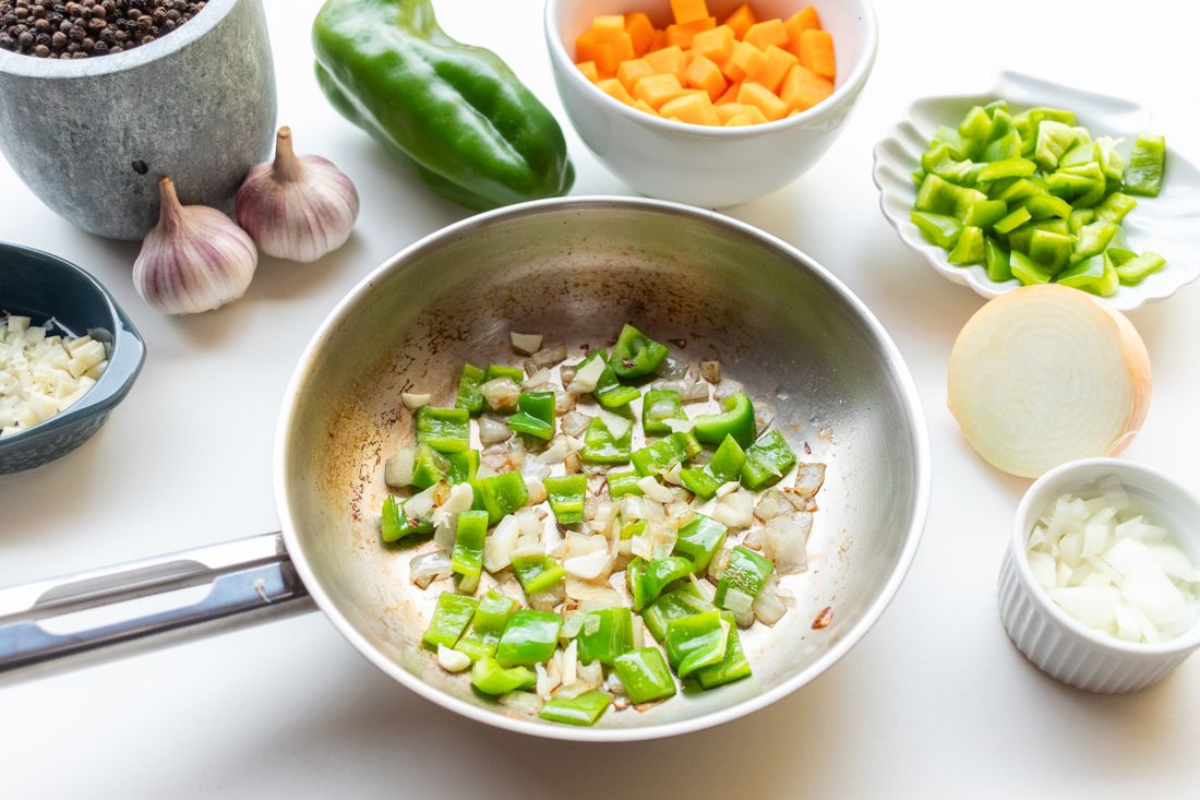 Green bell peppers and onions sauteing in a skillet. Photo by Laura oliveira on Pexels