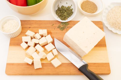 Free Sliced tofu on cutting board with herbs and spices, perfect for vegan meal ideas. Stock Photo