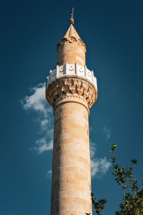 Free A stunning minaret tower in Muğla, Türkiye, captured against a clear blue sky, showcasing intricate architecture. Stock Photo