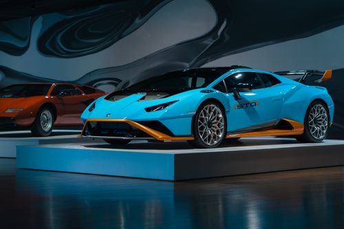 Free Modern supercar displayed in an elegant indoor gallery setting with stylish lighting. Stock Photo
