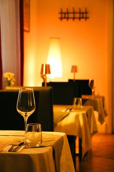 Cozy restaurant interior in Tbilisi, showcasing elegant table settings under warm ambient lighting.