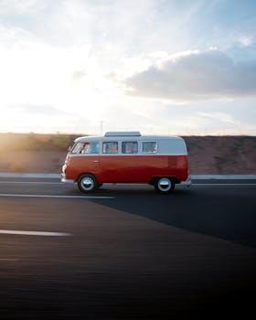 A classic Volkswagen van drives on a highway in Ankara, Türkiye during sunset.