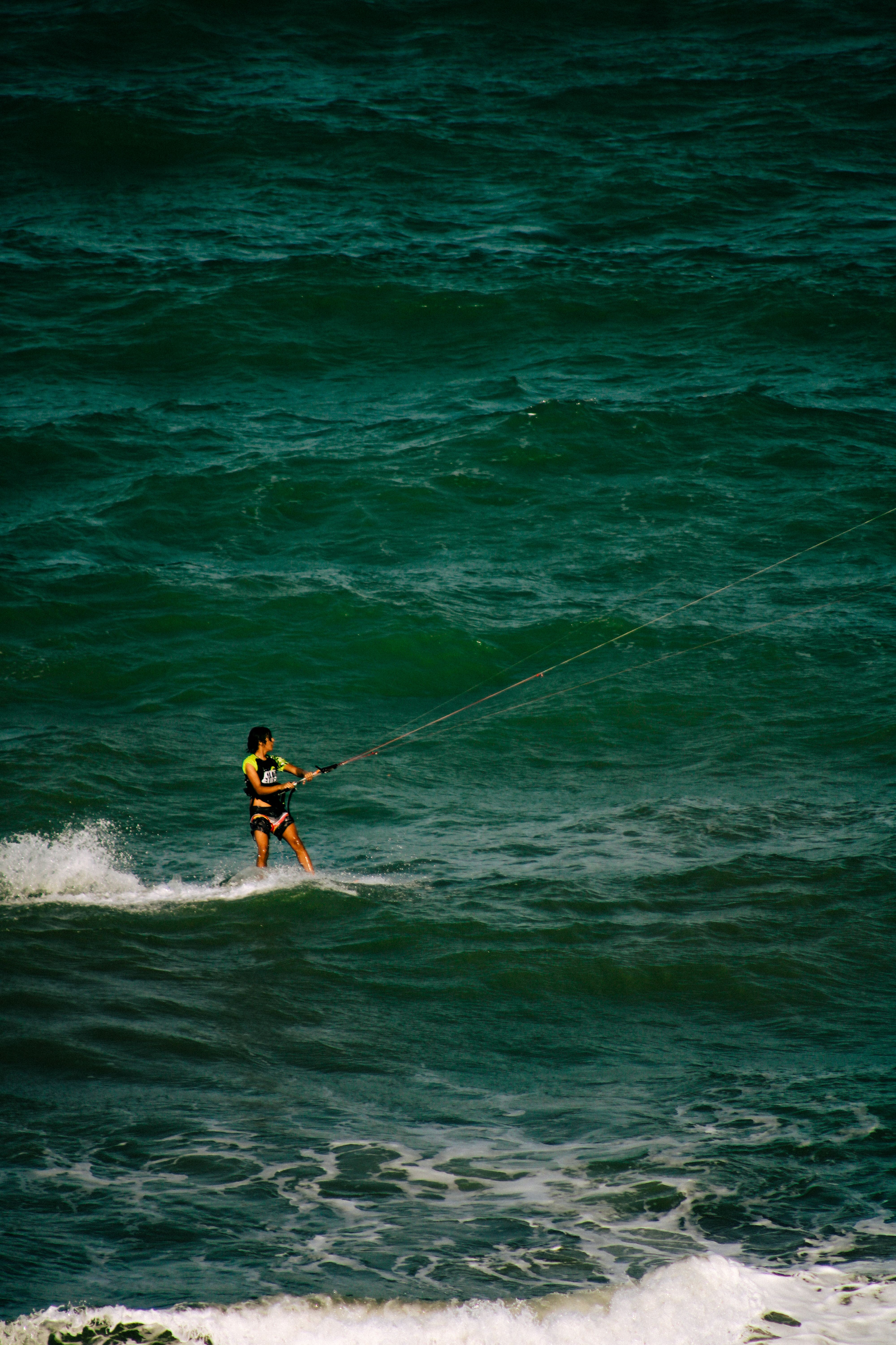 A lone kitesurfer navigates the ocean waves, showcasing skill and adventure at sea.