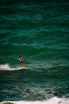 A lone kitesurfer navigates the ocean waves, showcasing skill and adventure at sea.