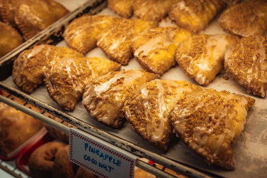 Delicious pineapple coconut turnovers fresh from the bakery, topped with glaze.
