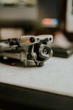A detailed close-up of a modern drone with high-tech camera lenses on a desk.