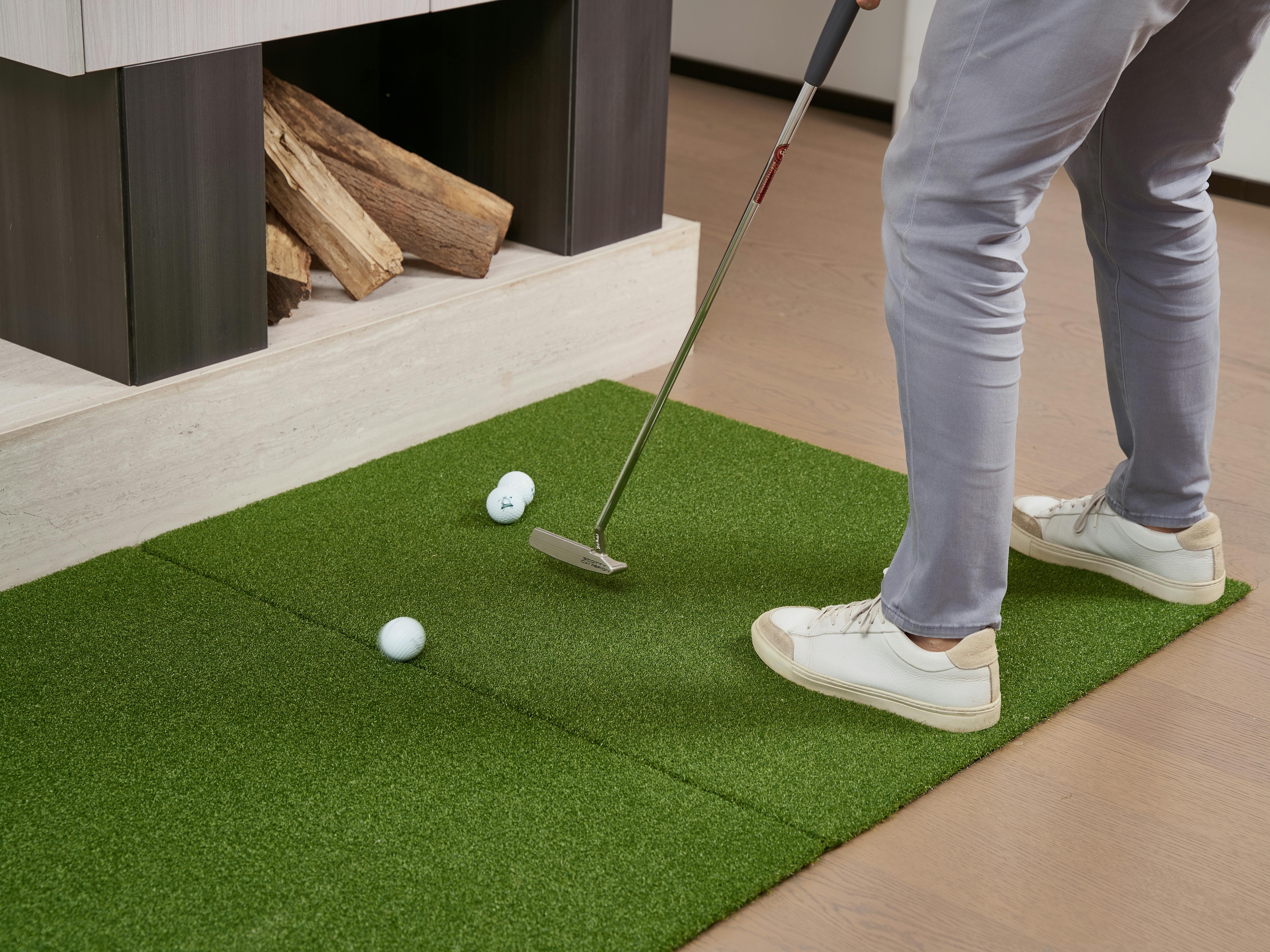 Golf putting practice on artificial turf indoors, perfect for home improvement.