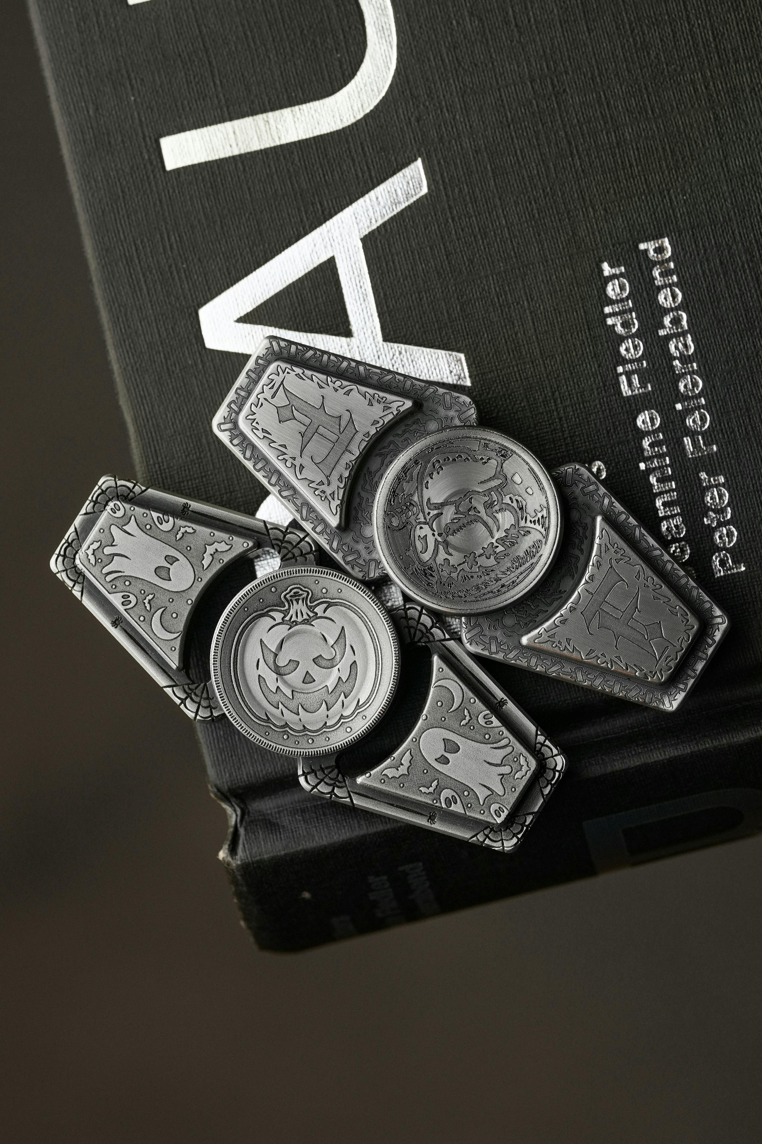 Detailed shot of intricate metal fidget spinner resting on a book, showcasing design.