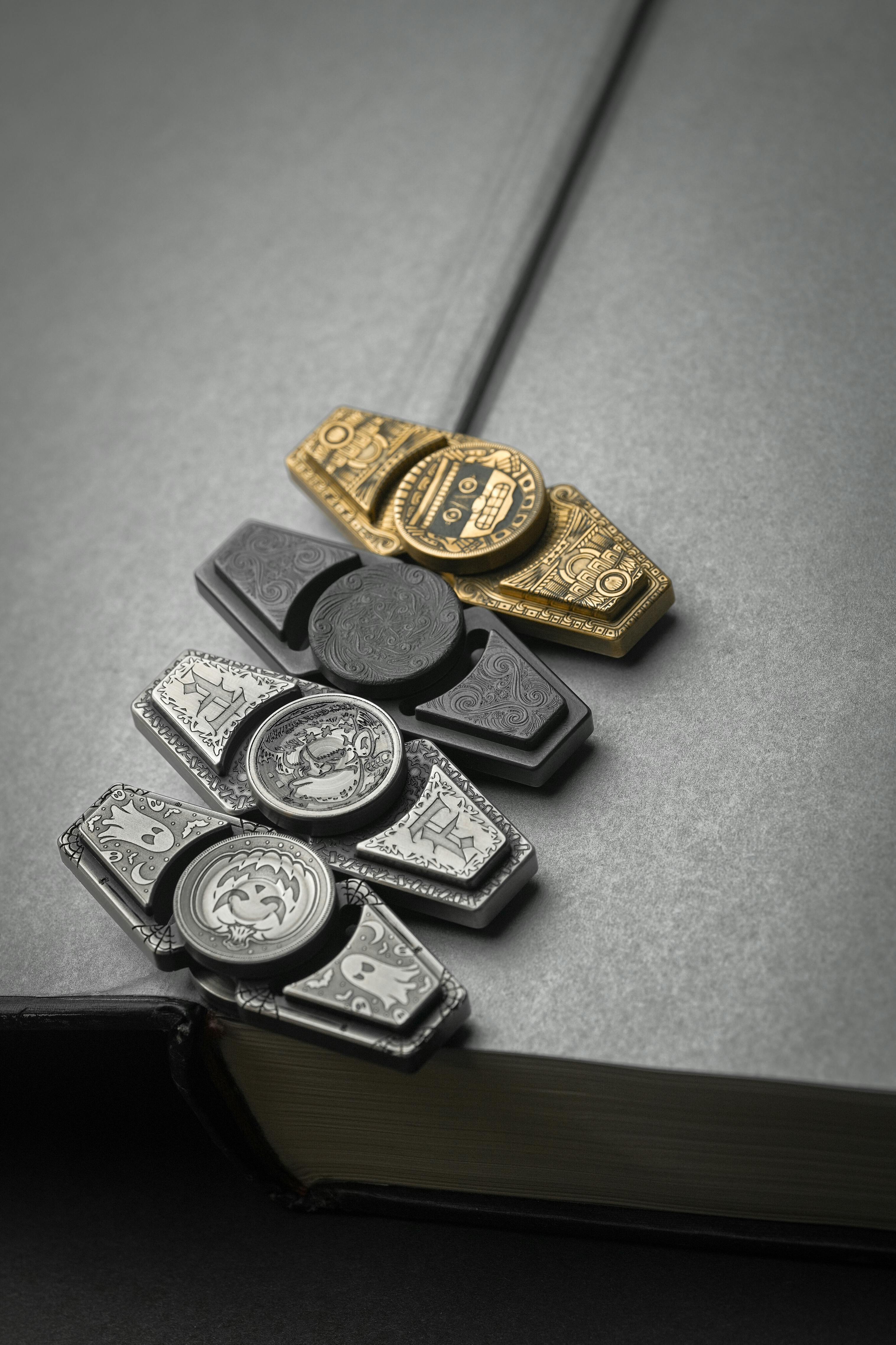 무료 회색 하드커버 책 위에 놓인 세련된 금속 책갈피는 정교한 디자인과 우아함을 보여줍니다. 스톡 사진