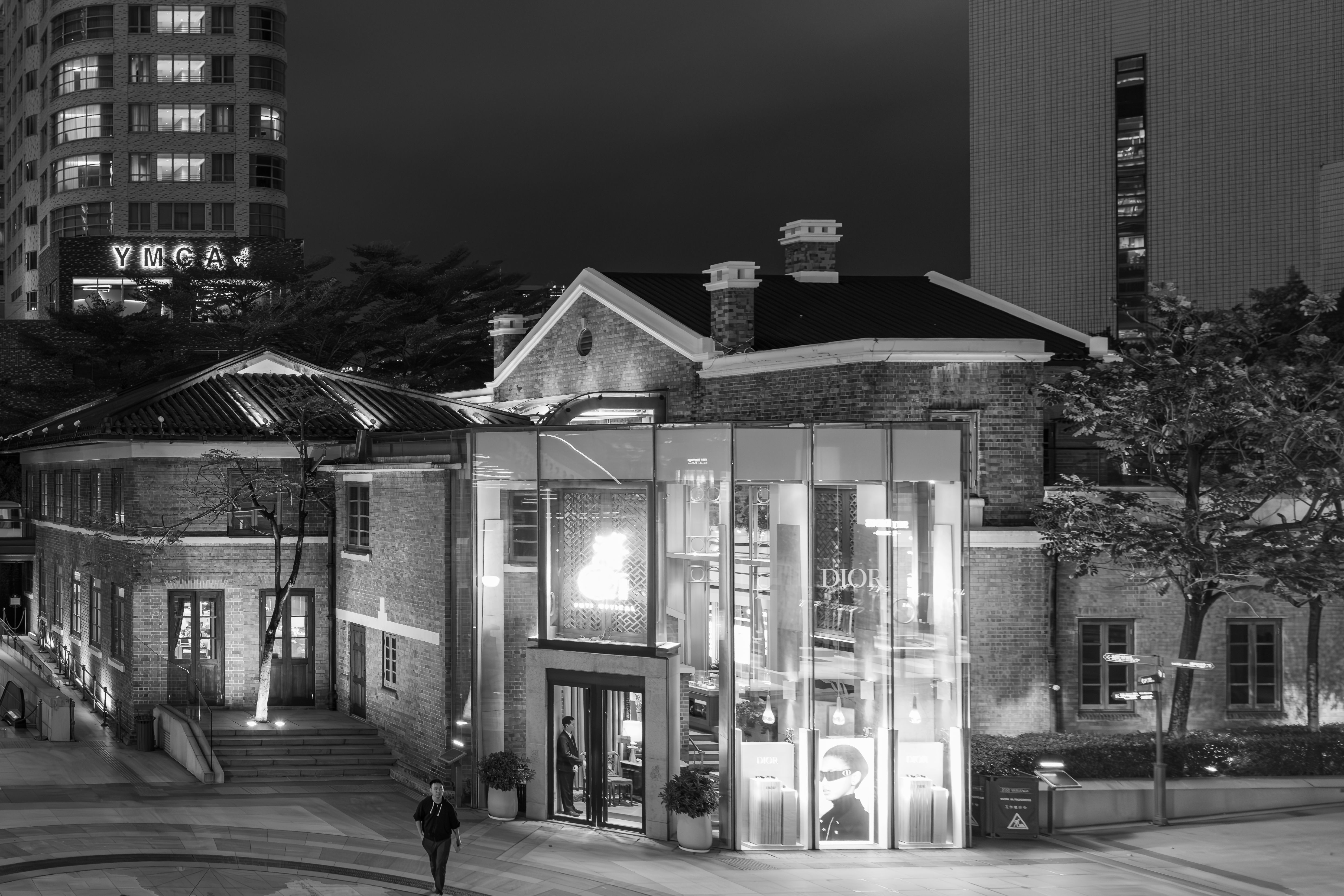 YMCA とディオールの建物が白黒で描かれた近代的な通りの夜景。