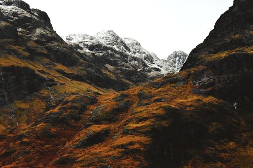 Free Breathtaking view of snow-capped peaks and vibrant autumn foliage in a remote mountain landscape. Stock Photo
