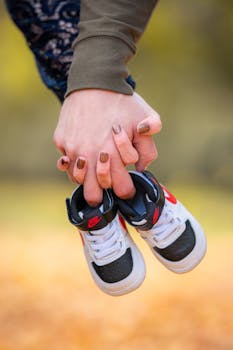 Hands of expecting parents holding baby shoes, a symbol of new beginnings.