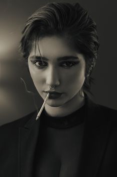 Black and white portrait of a woman with cigarette. Dramatic and artistic mood.