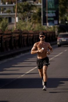 A fit man jogging on a city street showing determination and healthy lifestyle.