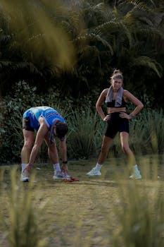 Two adults resting after a running session in a natural outdoor setting.