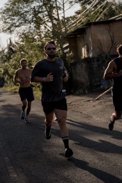 Free Group of men jogging outdoors, showcasing fitness and healthy lifestyle in a natural setting. Stock Photo