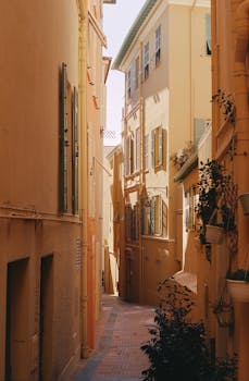 Explore a serene sunlit alleyway in Monaco, highlighting Mediterranean charm and architecture.