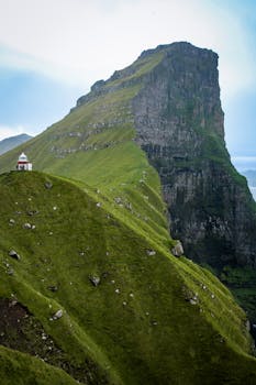 Stunning view of Klakkur Mountain's green cliffs in Trøllanes, Faroe Islands.