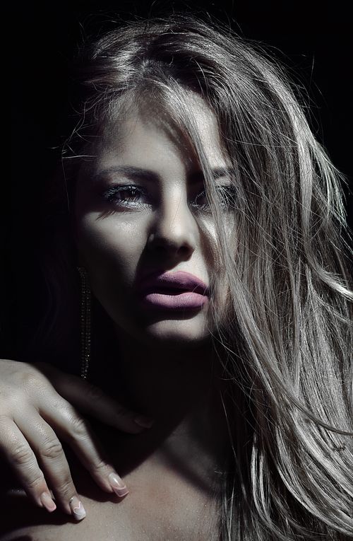 Free Striking portrait of a woman in dramatic lighting highlighting features and expression. Stock Photo