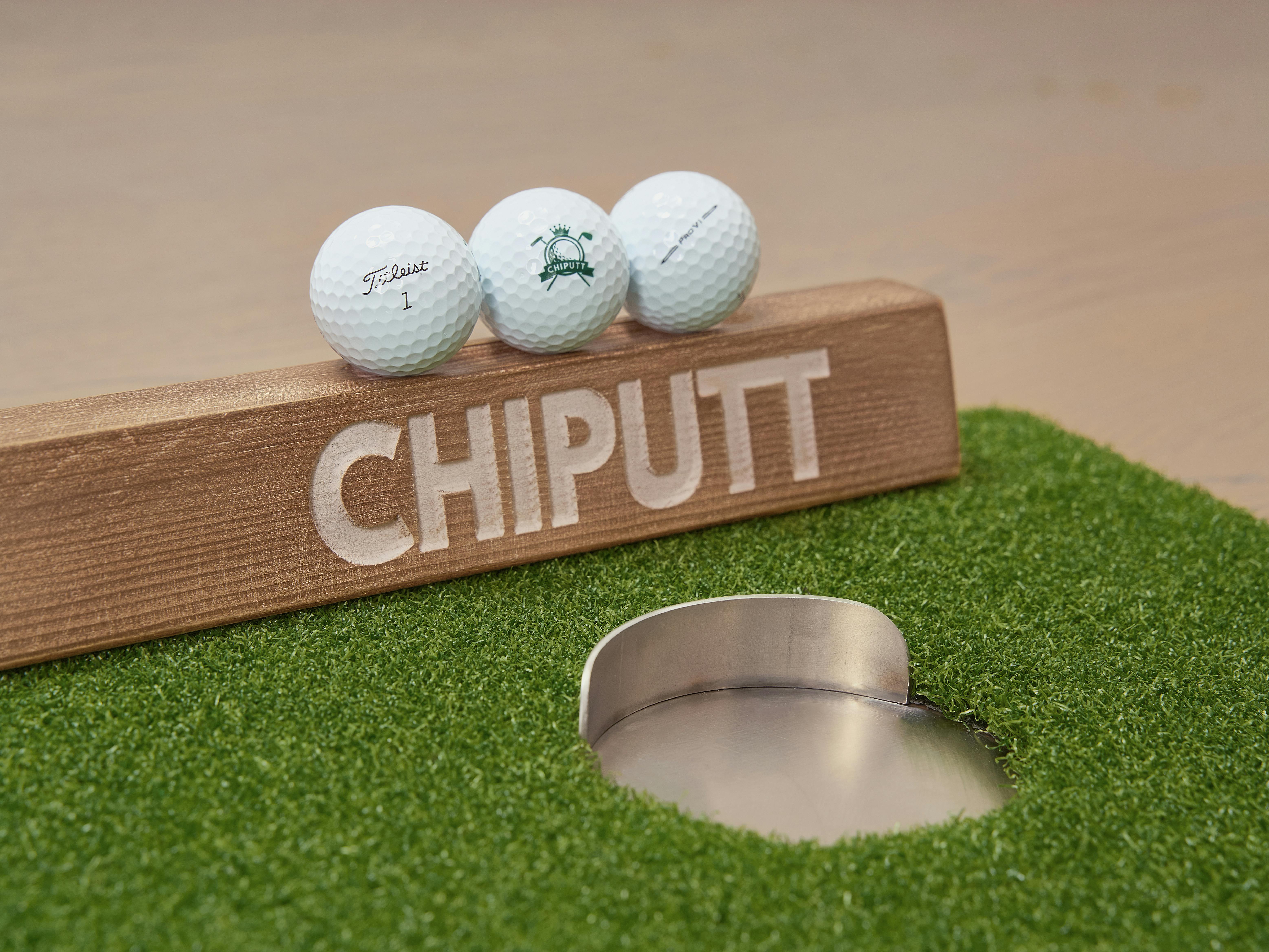 Enhance your golf skills with a wooden Chiputt training aid on artificial turf.