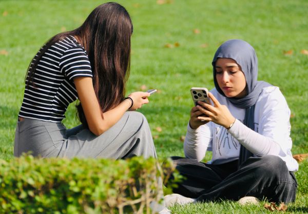 Two young women using smartphones